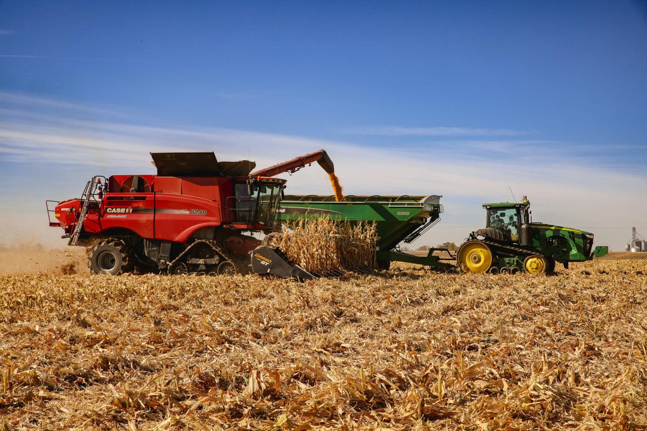 a red tractor and a green tractor in a field