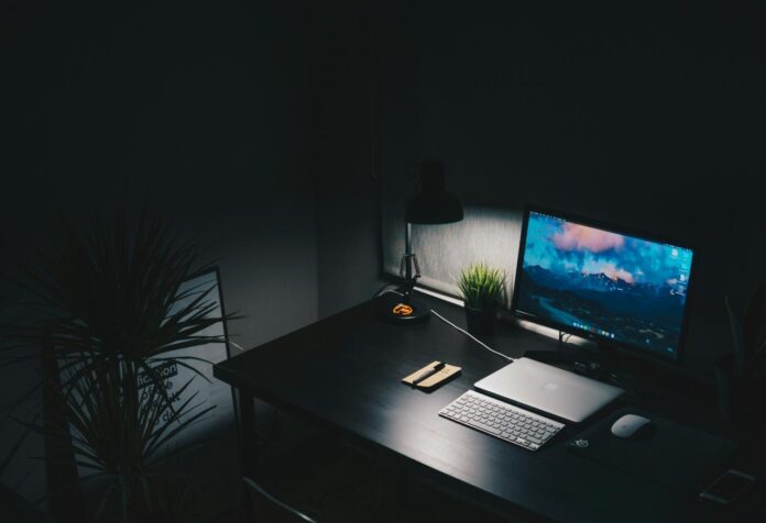meja dengan monitor komputer dan keyboard di atasnya