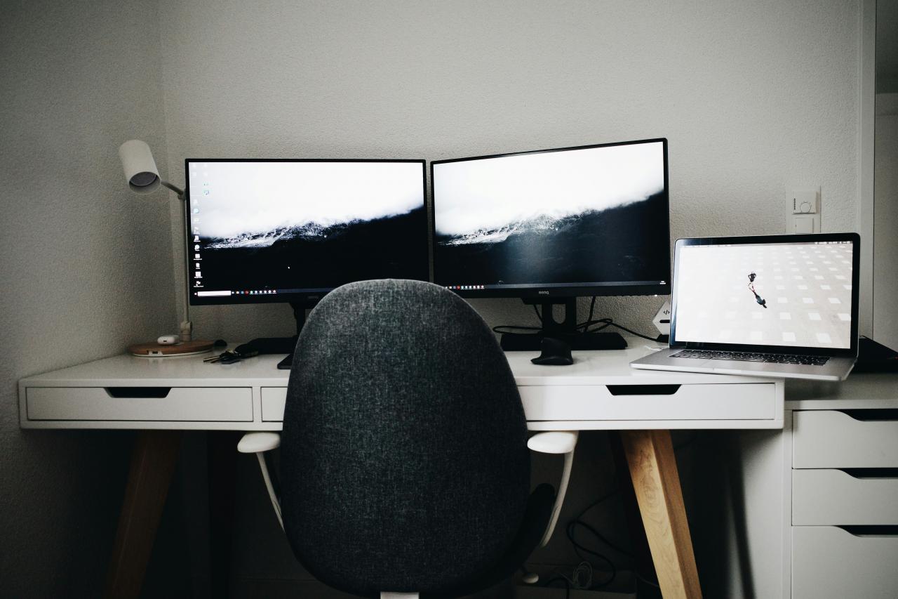 2 monitor komputer layar datar hitam di atas meja kayu putih