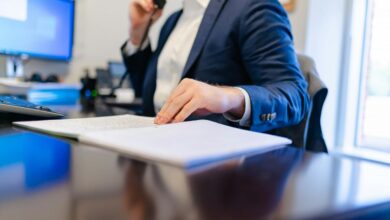 seorang pria duduk di meja menulis di selembar kertas