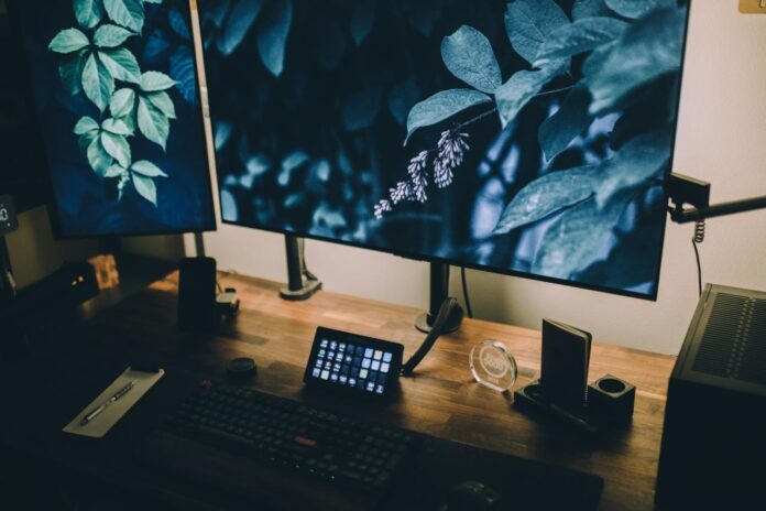 komputer desktop yang duduk di atas meja kayu